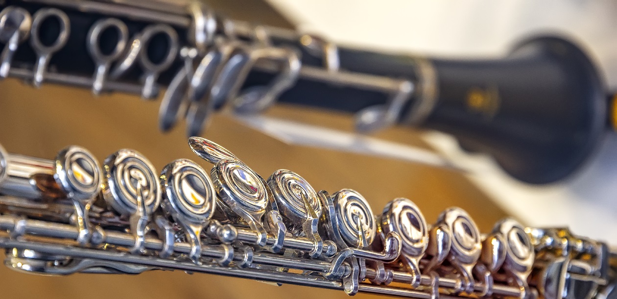 A part of the classical wind instrument flute with brass details. Close up of trumpet finger buttons valves
