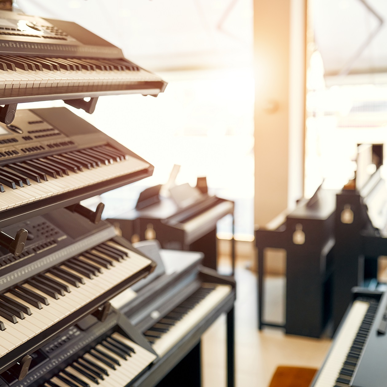 Close-up of synthesizers and midi keyboards in a musical instrument store. Lots of different keyboard instruments for sale. Hobbies and recreation.
