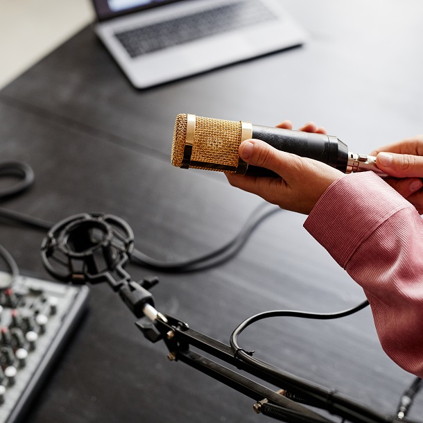 Close up of young woman setting up microphone and recording equipment in studio, copy space